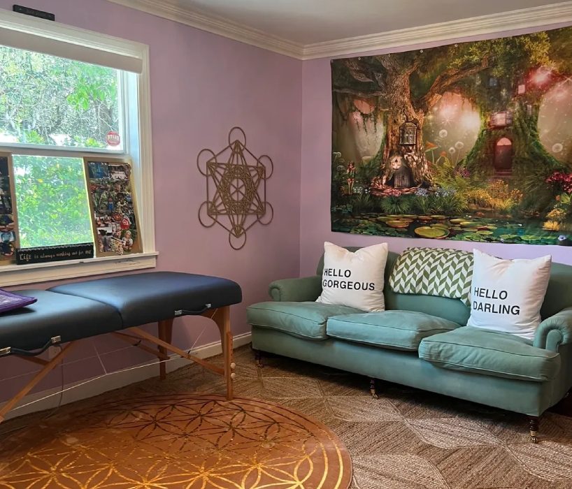 A couch and table in a room with a wall mural.