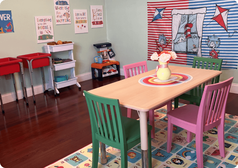 A table and chairs in a room with toys on the floor.