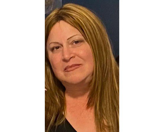 A woman with long hair and a black shirt.